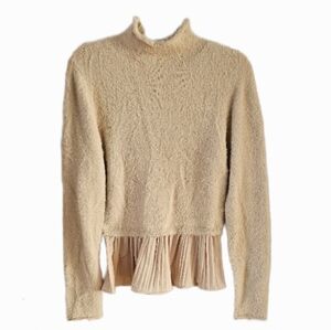 Greige fuzzy knit sweater with a pleated hem.